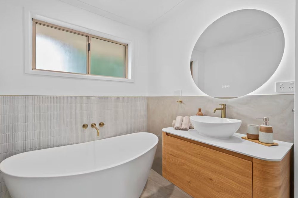 Freestanding bath and timber vanity with backlit mirror