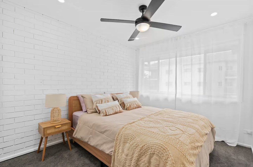 Second queen bedroom with white brick feature wall
